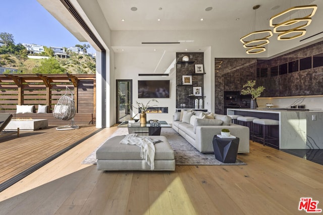 living room with a large fireplace, hardwood / wood-style floors, and a notable chandelier