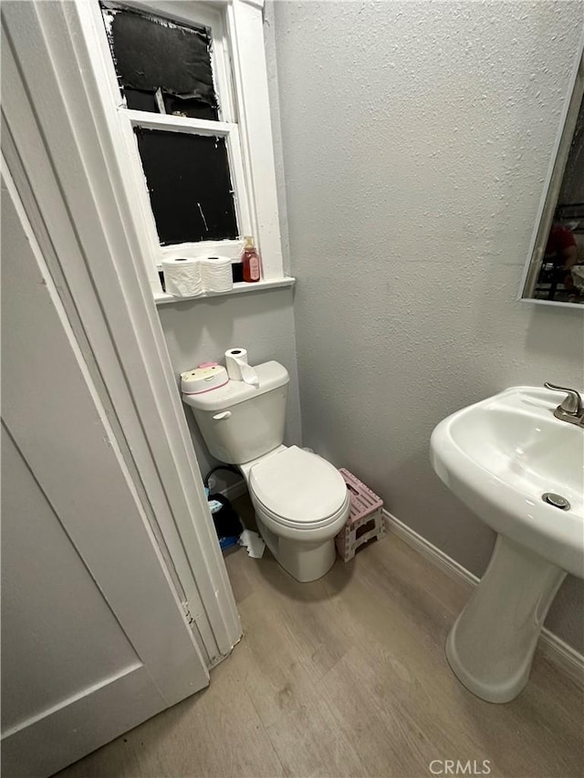 bathroom with hardwood / wood-style flooring and toilet