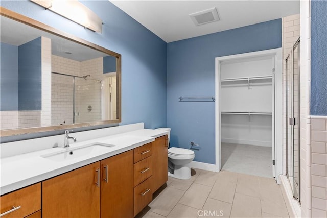 bathroom with vanity, toilet, tile patterned floors, and a shower with shower door