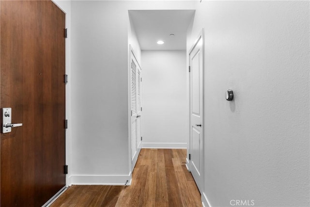 hallway with hardwood / wood-style floors