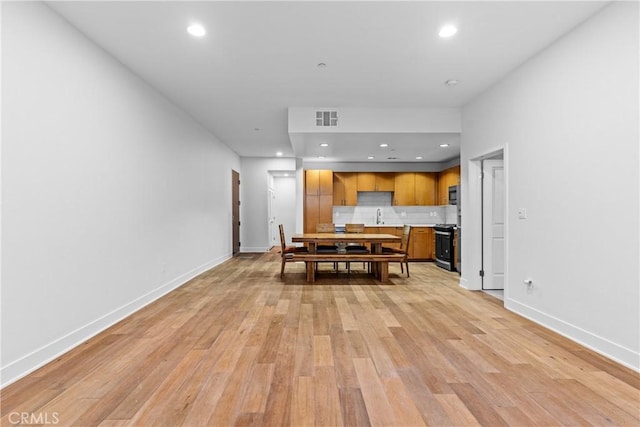 dining area with sink and light hardwood / wood-style flooring