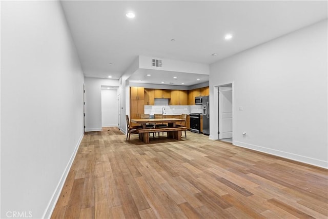 kitchen with light hardwood / wood-style floors, decorative backsplash, and range with electric stovetop