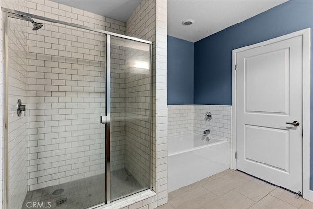 bathroom featuring shower with separate bathtub and tile patterned flooring