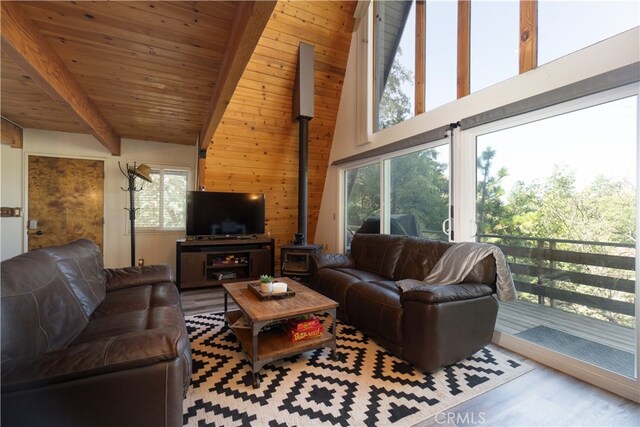 1154 Yukon Dr, Lake Arrowhead, CA 92352 - living area featuring beam ceiling, wood finished floors, wooden walls, a wood stove, and high vaulted ceiling