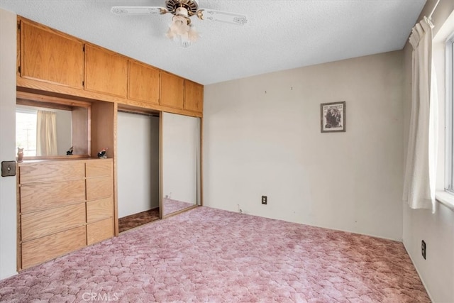 bedroom with a closet, carpet, a textured ceiling, and ceiling fan