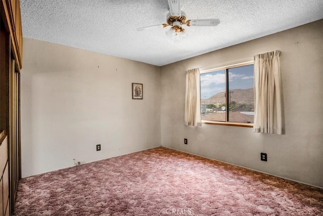 unfurnished room with ceiling fan, carpet floors, and a textured ceiling