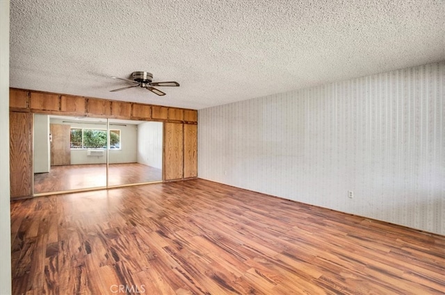 spare room featuring hardwood / wood-style flooring, a textured ceiling, and ceiling fan