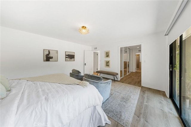 bedroom with access to outside and light hardwood / wood-style flooring