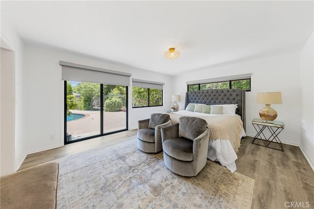 bedroom with light wood-type flooring and access to outside