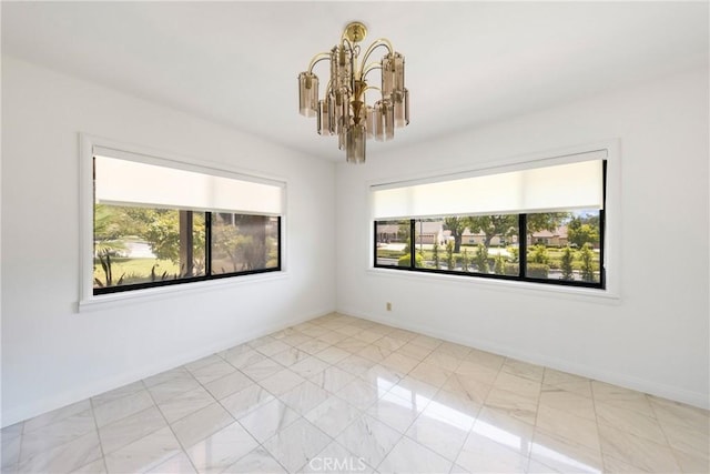 spare room with a wealth of natural light and a notable chandelier