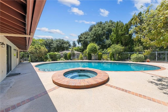 view of swimming pool featuring a patio area and an in ground hot tub