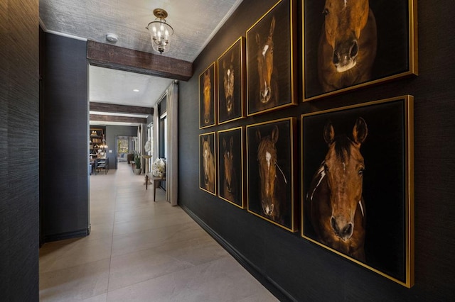 hallway featuring light tile patterned floors, beamed ceiling, a chandelier, and a textured ceiling