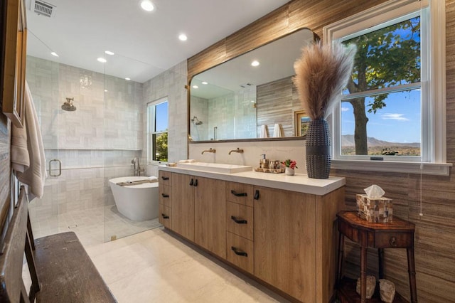 bathroom featuring a mountain view, vanity, separate shower and tub, tile patterned floors, and tile walls