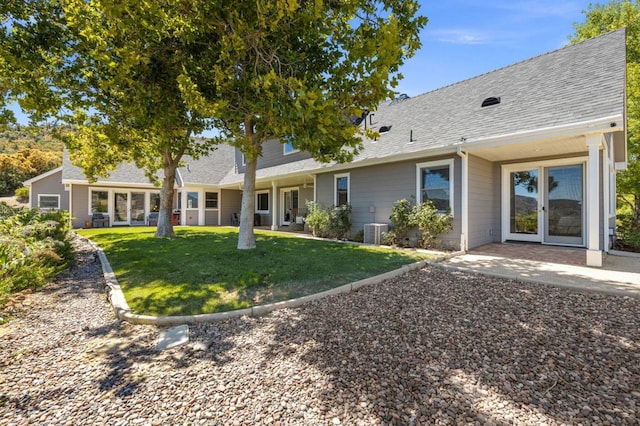 back of property featuring cooling unit and a yard