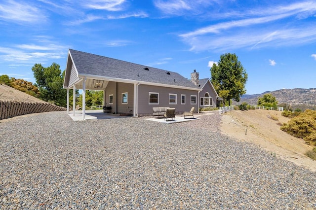 rear view of house with a patio and a mountain view