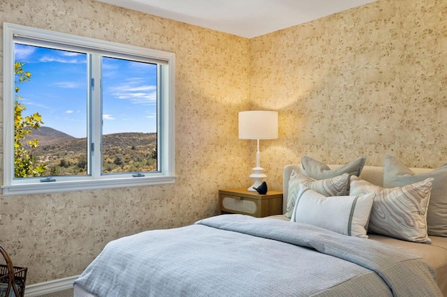 bedroom with a mountain view and multiple windows