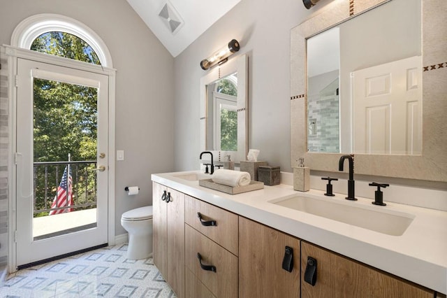 bathroom featuring tile patterned flooring, vaulted ceiling, vanity, and toilet