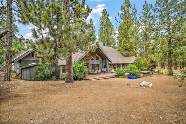 view of front of home with a storage unit and a patio area