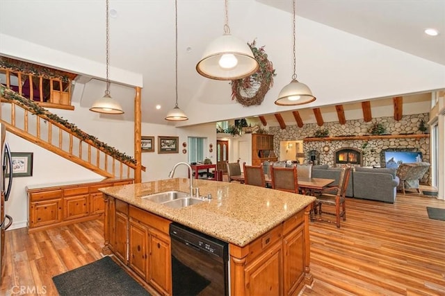 kitchen featuring sink, lofted ceiling with beams, dishwasher, an island with sink, and pendant lighting