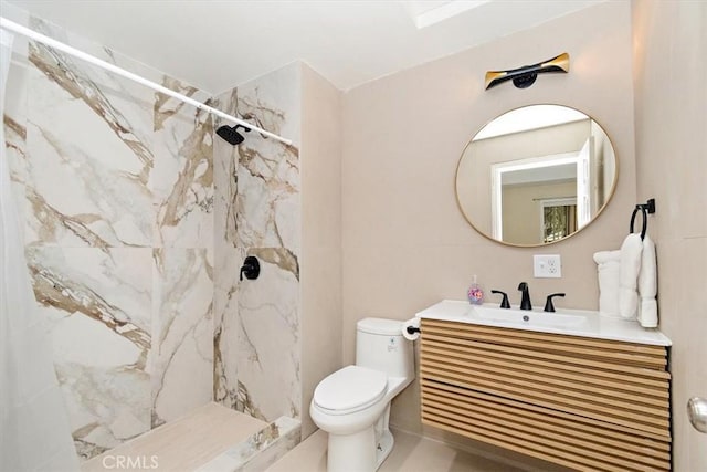 bathroom with vanity, tiled shower, and toilet