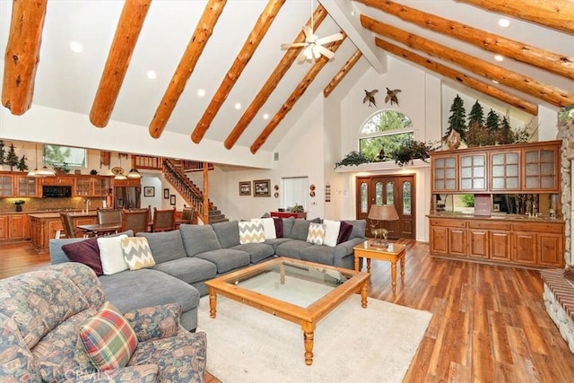 living room featuring beamed ceiling, wood-type flooring, and high vaulted ceiling