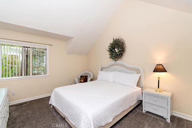 bedroom with lofted ceiling and dark carpet