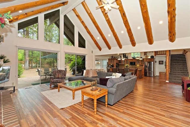 living room featuring beam ceiling, wood-type flooring, and high vaulted ceiling