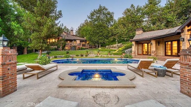 view of swimming pool featuring an outbuilding, a patio area, and an in ground hot tub