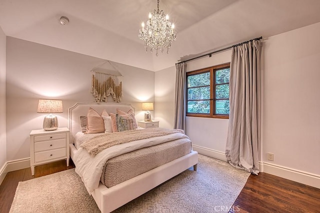 bedroom with a notable chandelier and dark hardwood / wood-style floors