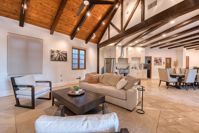 living room featuring visible vents, beamed ceiling, high vaulted ceiling, baseboards, and wood ceiling