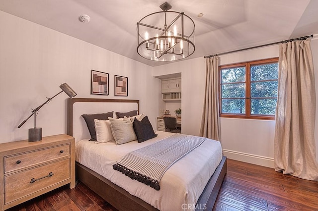 bedroom with dark wood finished floors, a notable chandelier, and baseboards