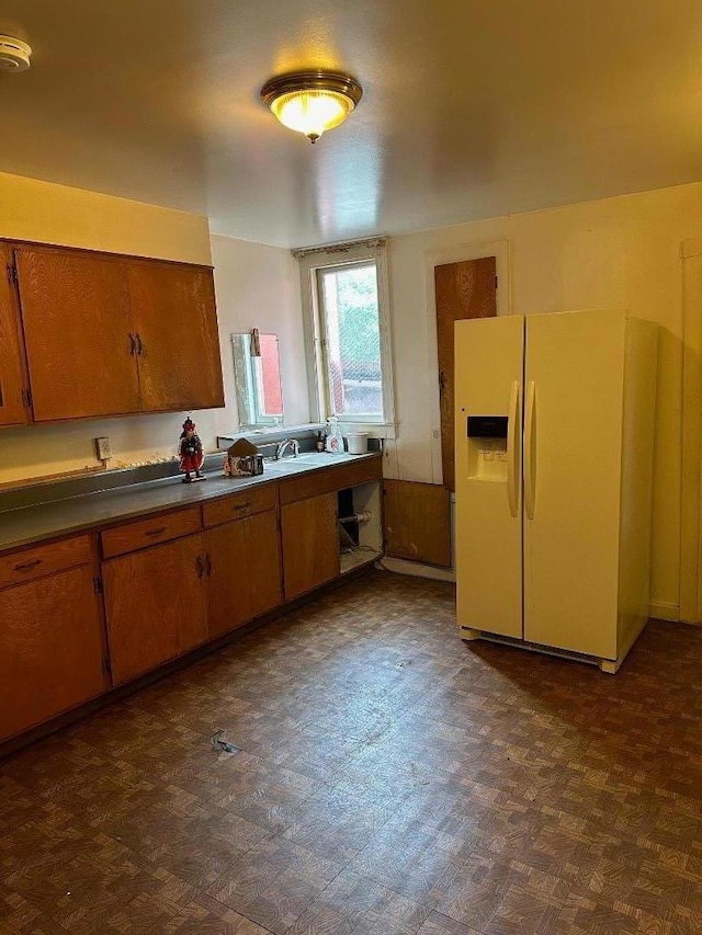 kitchen featuring sink and white fridge with ice dispenser