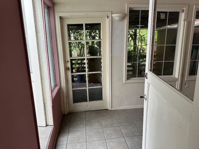 doorway to outside with light tile patterned floors