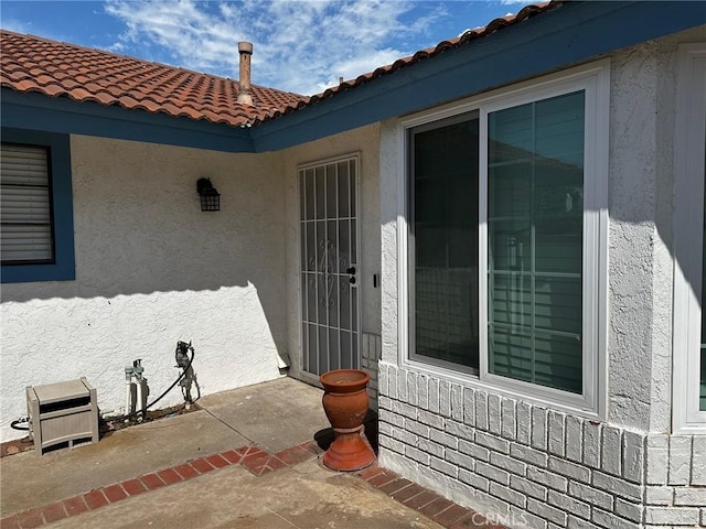 view of exterior entry with a patio