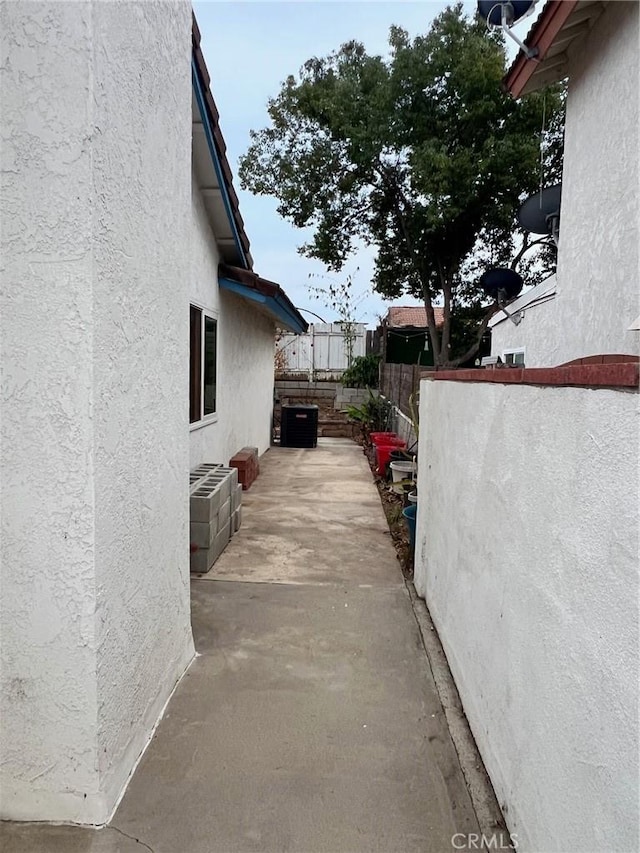 view of property exterior with cooling unit and a patio