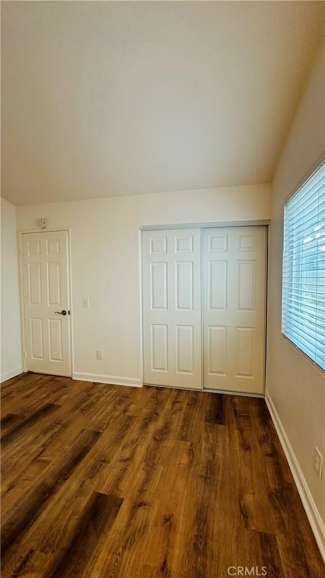 unfurnished bedroom featuring a closet and dark hardwood / wood-style floors