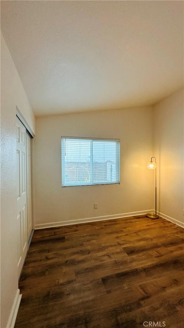 unfurnished bedroom with a closet and dark hardwood / wood-style floors