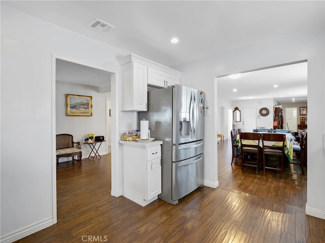 kitchen featuring white cabinets, stainless steel fridge, and dark wood-type flooring