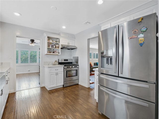 kitchen featuring appliances with stainless steel finishes, light stone counters, white cabinets, ceiling fan, and dark hardwood / wood-style floors