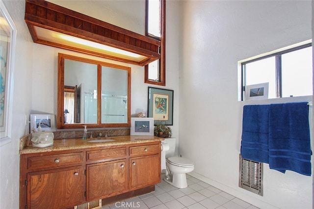 bathroom with toilet, tile patterned flooring, walk in shower, and vanity