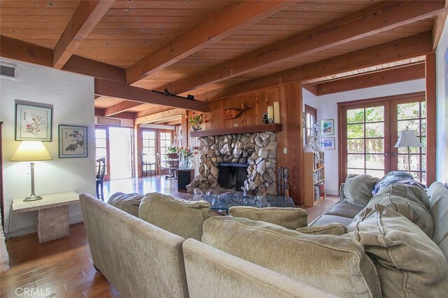 living room featuring french doors, a stone fireplace, hardwood / wood-style flooring, and wooden ceiling