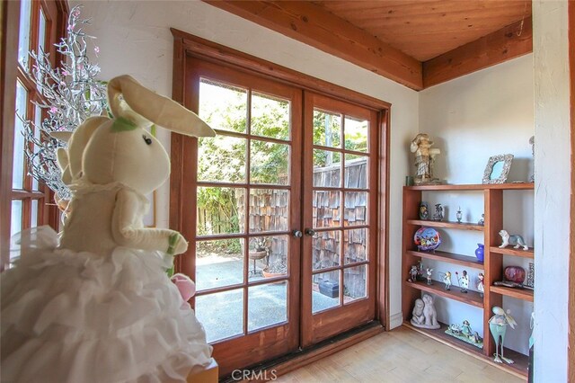 doorway featuring light wood-type flooring, wood ceiling, beam ceiling, and french doors