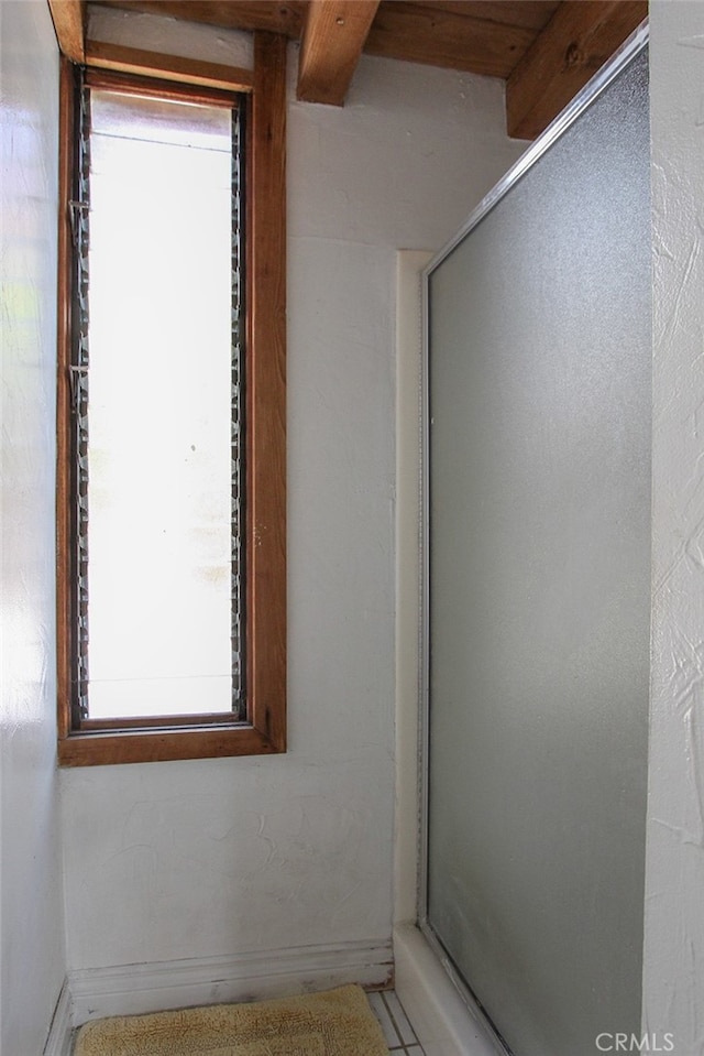 bathroom with a shower stall and baseboards