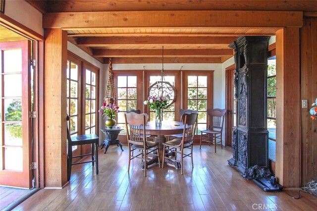 unfurnished dining area featuring wood ceiling, wood-type flooring, beam ceiling, and french doors