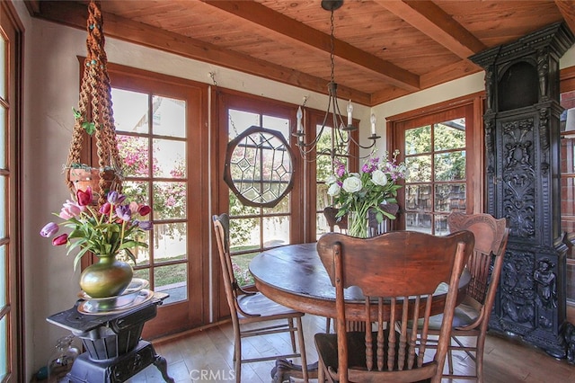 dining room with wood ceiling, a wealth of natural light, hardwood / wood-style flooring, and beamed ceiling