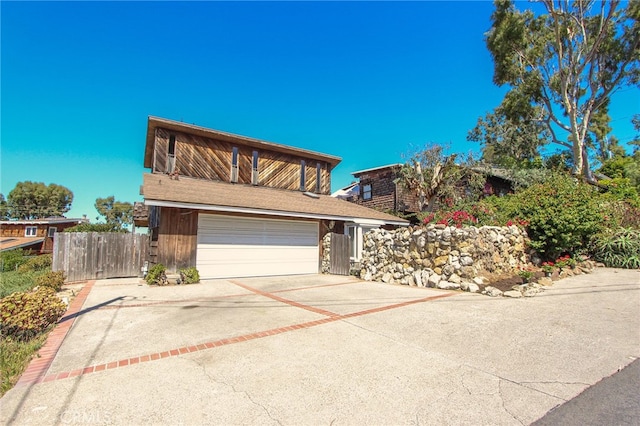 traditional home with a gate, fence, driveway, and an attached garage