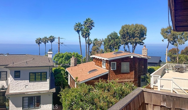 view of side of property featuring a chimney, a balcony, and stucco siding