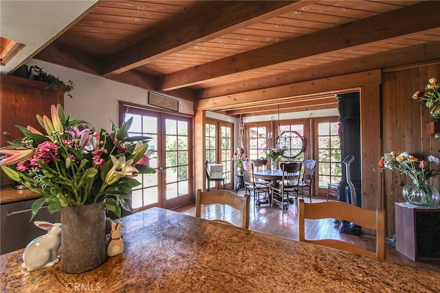 dining space featuring a wealth of natural light, french doors, wood finished floors, and beamed ceiling