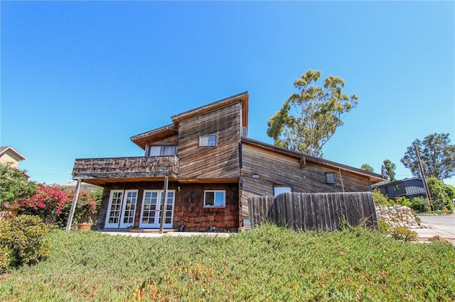 back of house featuring a lawn and french doors