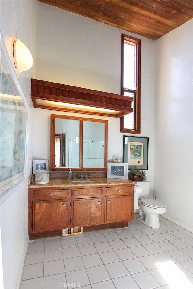 bathroom featuring tile patterned flooring, wooden ceiling, vanity, and toilet